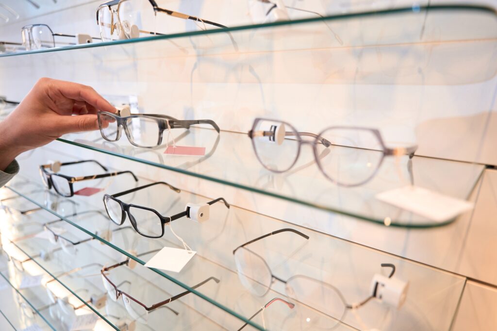 Unrecognized person is looking for the eye glasses for the gift in the store